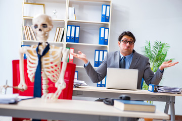 Businessman working with skeleton in office