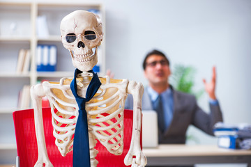 Businessman working with skeleton in office