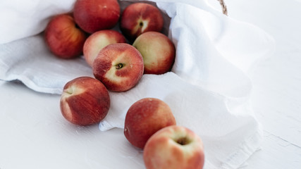 Peaches in basket on white linen