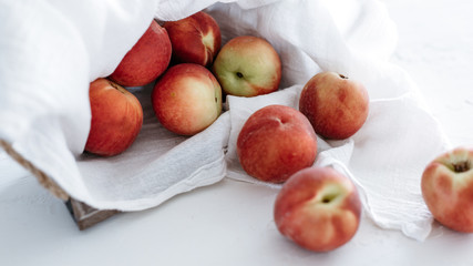 Peaches in basket on white linen