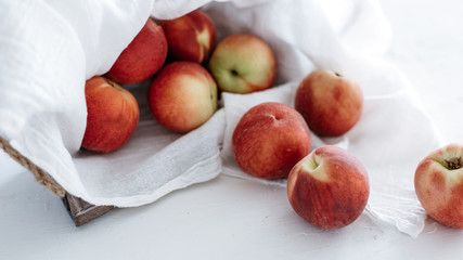 Peaches in basket on white linen