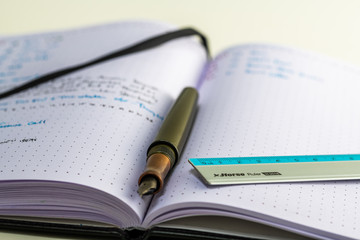 Notebook with writing, ruler, pencil, fountain pen