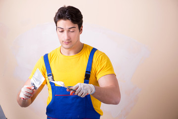 Young contractor employee applying plaster on wall