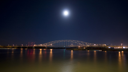 Fototapeta na wymiar Bridge at night over the mighty Mississippi river barges