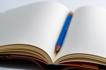 An open blank paper notebook with a pencil 