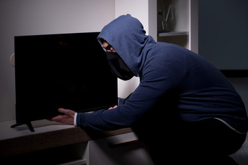 Burglar thief stealing tv from apartment house
