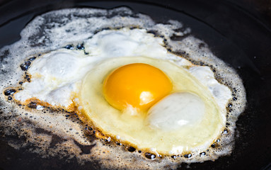 An fried egg in butter in a carbon steel frying pan