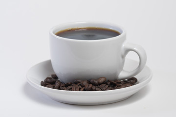 Coffee cup filled with hot fresh coffee with a drip of coffee being poured in