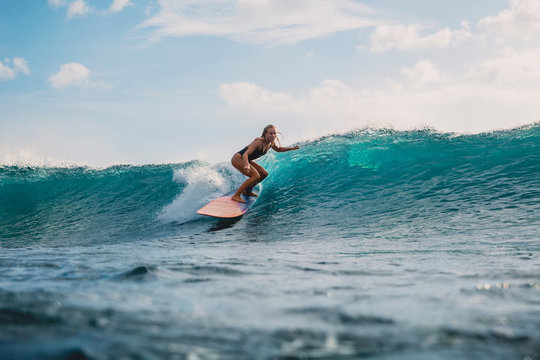 Professional surf girl on surfboard. Woman in ocean during surfing. Surfer and ocean wave