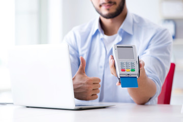 Man processing credit card transaction with POS terminal
