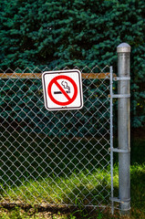 A No Smoking Sign on a chain-link fence