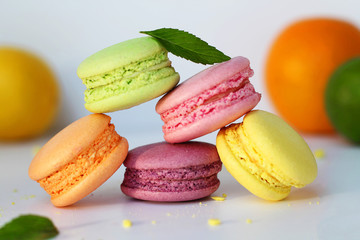 Macaroon, beze, meringue is a French dessert. Egg whites with sugar, whipped and baked. They lie on a table with fresh berries and fruits. Dessert for gourmets. Side view, selective focus.