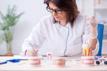 Woman dentist working on teeth implant