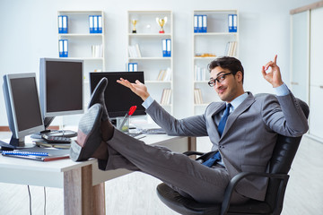 Businessman sitting in front of many screens