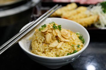 Garlic fried rice on the white plate and metal chopsticks