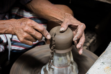 Fototapeta na wymiar Closed-up hands of a old man to make pottery. Pottery is the ceramic material which makes up pottery wares, of which major types include earthenware, stoneware and porcelain.