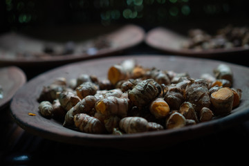 Closeup dried galangal on the rustic clay brown plate