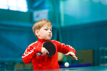 boy in red clothing, playing table tennis