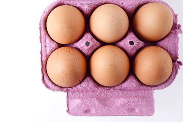 Top view of six brown eggs on box