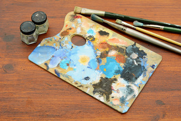 Artist's palette with colorful oil paint strokes and paintbrushes