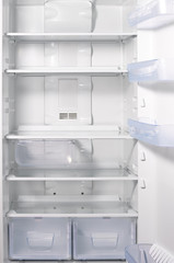 Empty open fridge with shelves, white refrigerator background.