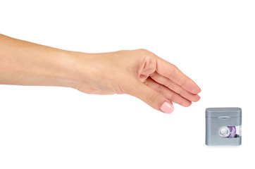 Dental floss in grey container with hand isolated on white background.