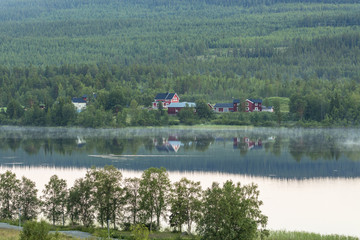 Fototapeta na wymiar House reflecting in the water by a lake
