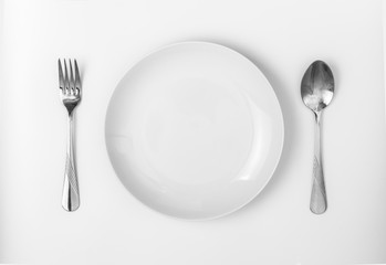 Top view empty white dish on table with fork and spoon
