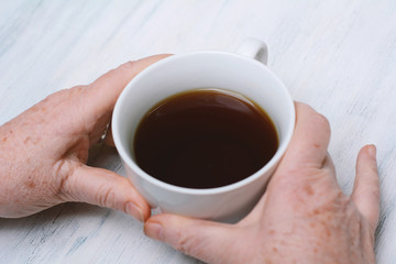 Close up of senior man holding cup of coffee