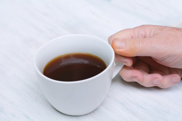Close up of senior man holding cup of coffee