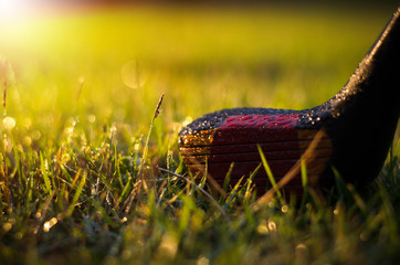Golf clubs are wet with warm light rain at sunset