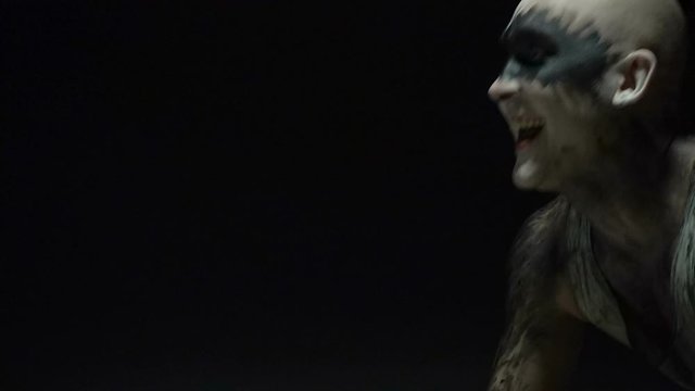 Yelling psycho bald man in black room