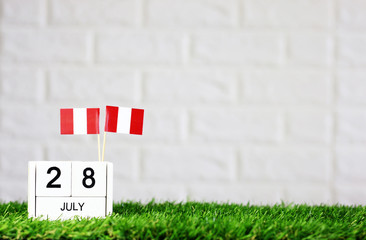 Obraz premium July 28 Wooden calendar and Peru Flag Concept Peru national day with space for your text