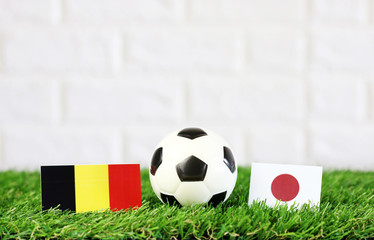 ball with Belgium VS Japan flag match on Green grass football 2018