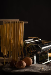 Freshly prepared Tagliatelle paste is dried on a wooden drier. Traditional italian cuisine