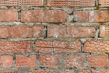 Wall of old red brick and gray cement.