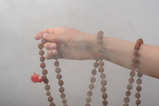 Female hands with rosary  in smoke