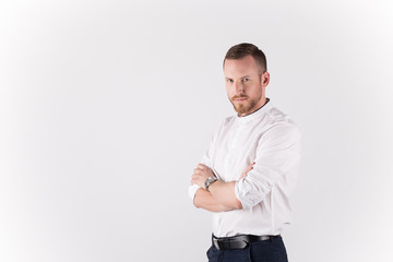 Handsome young man in casual wear keeping arms crossed  while standing