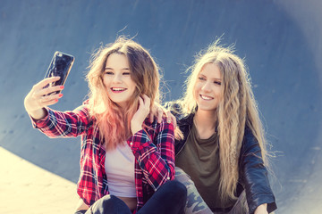 Happy girl friends taking a selfie on a summer day