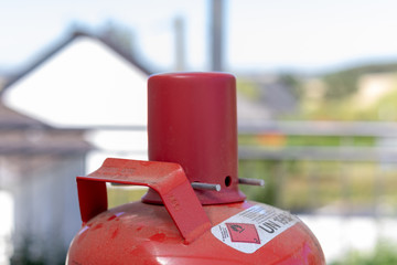 Rote Abdeckkappe auf dem Ventil einer roten Gasflasche 