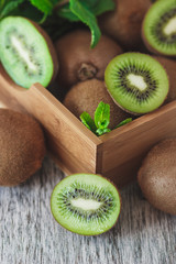 Green kiwis and mint leaves in the wooden tray