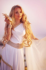 Beautiful girl in a long white wedding dress in Greek style is the old Greek goddess © olenakucher