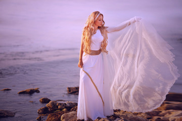 Beautiful girl in a long white wedding dress in Greek style is the old Greek goddess - obrazy, fototapety, plakaty