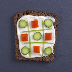 Vegetarian sandwiches with cream cheese, cucumbers, red tomato and parsley, healthy snack on black...