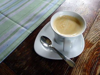 A cup of coffee with foam on a wooden table