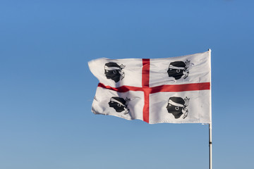 Flag of Sardinia - the four moors (italian i quattro mori) with blue sky background, Sardinia, Italy