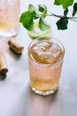 A glass of pink wine in a crystal glass on a marble background, green ivy and bright sun