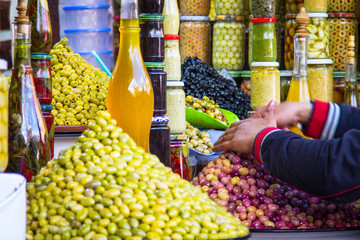 Olives and various spicy pickles in a large bowl on the shelves at the market in Marrakesh....