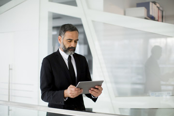 Middle age businessman with tablet in the office