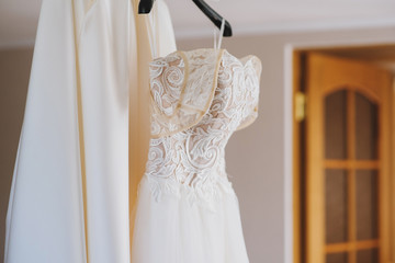 Beautiful wedding dress hanging on the chandelier in the room
